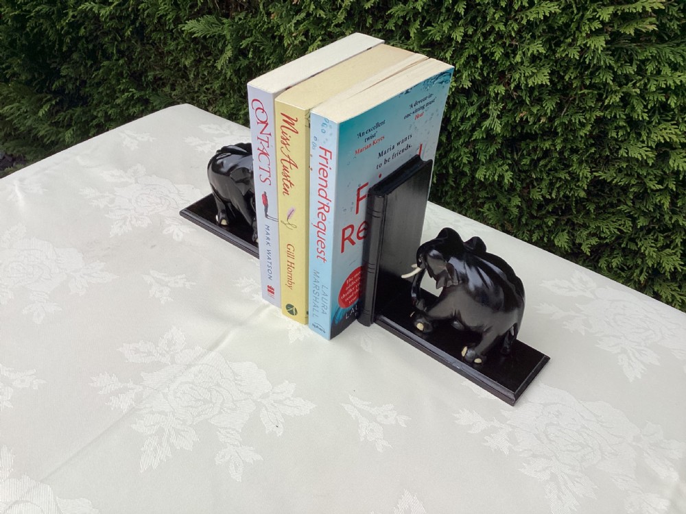 A pair of hand-carved dark coromandel wood elephant bookends featuring inlaid bone tusks and toes set on rectangular L-shaped bases. View VII