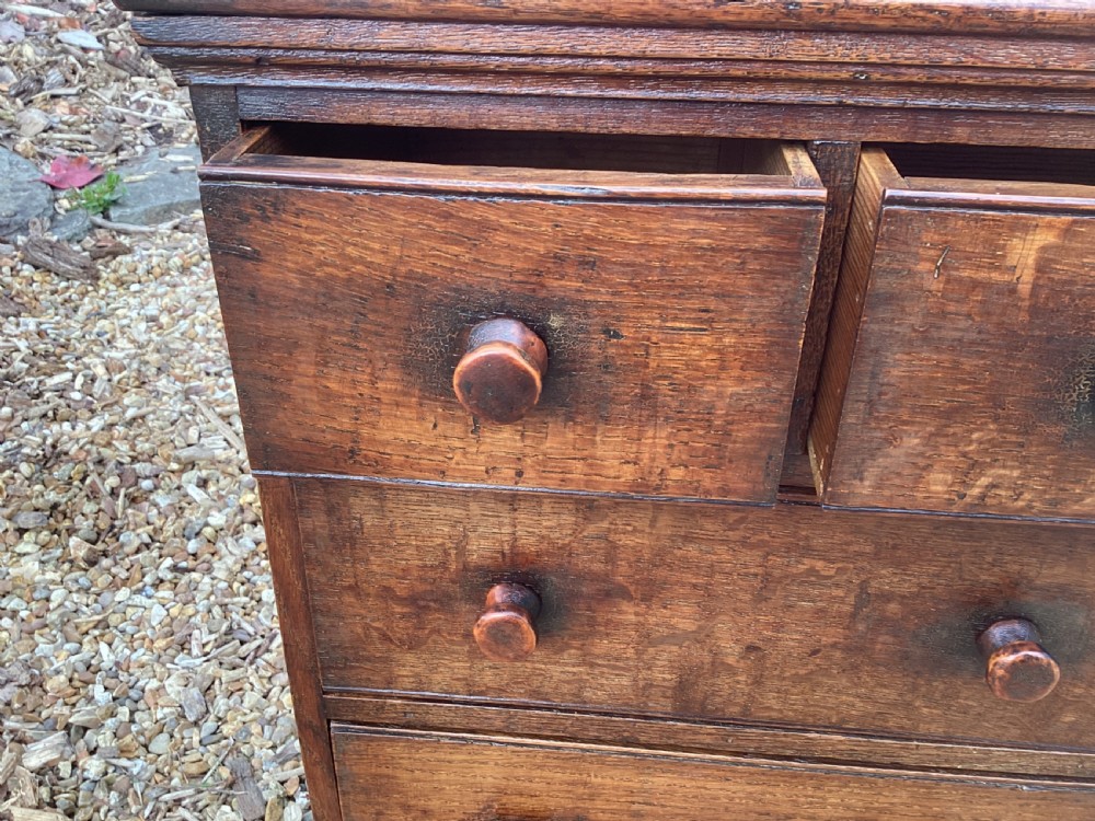 A small Georgian style miniature wooden chest of drawers featuring two short drawers over two long drawers with turned wooden knobs and bracket feet. View IX
