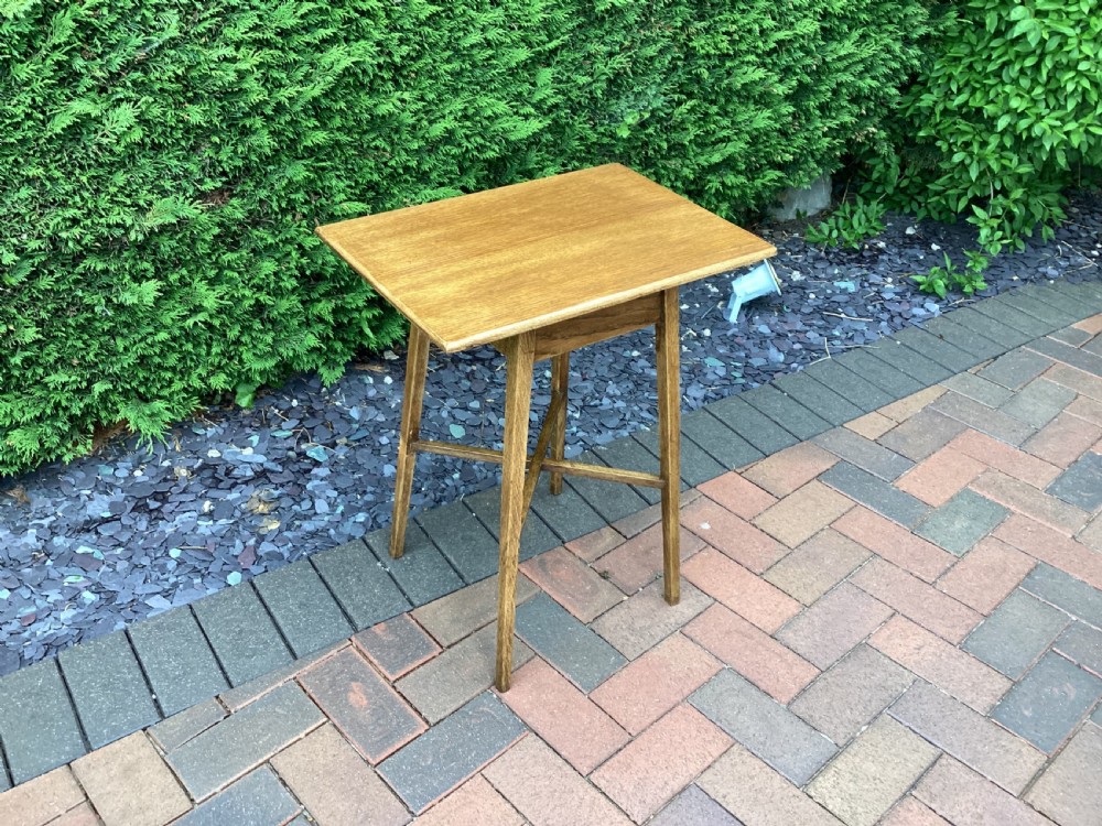 A rectangular solid oak Arts and Crafts side table featuring splayed tapered legs and an X-frame lower stretcher. View II