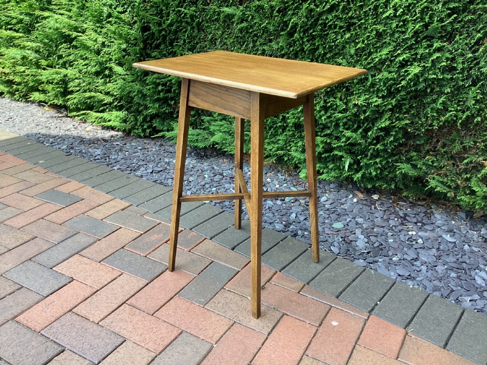 A rectangular solid oak Arts and Crafts side table featuring splayed tapered legs and an X-frame lower stretcher. View V