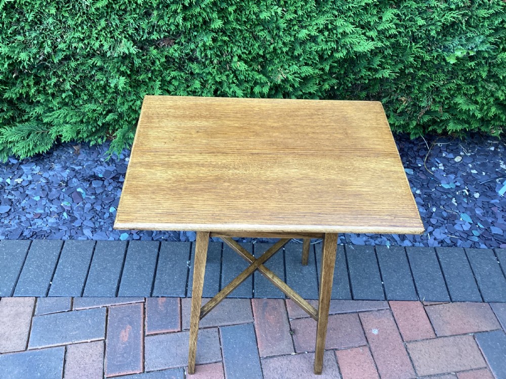 A rectangular solid oak Arts and Crafts side table featuring splayed tapered legs and an X-frame lower stretcher. View VI