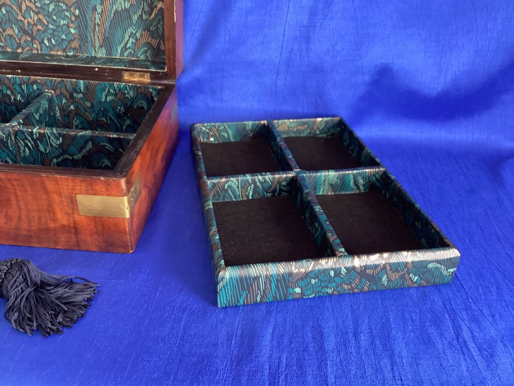 A rectangular Victorian walnut wooden box featuring protective brass corner brackets, a central keyhole escutcheon plate, and an inlaid lid cartouche. View VII