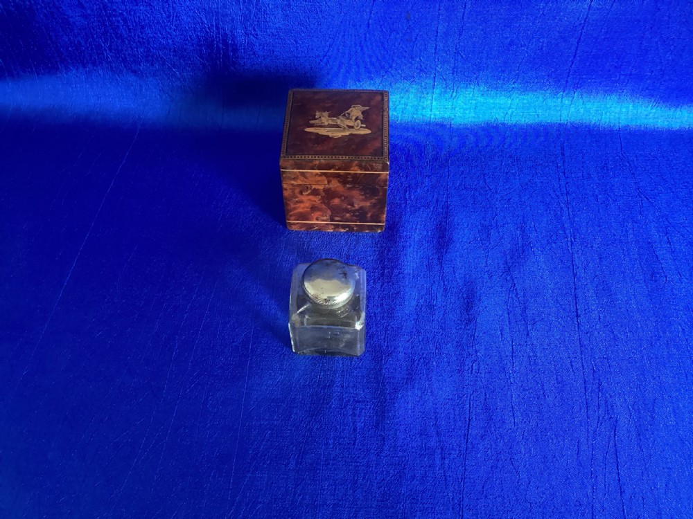 A small square Victorian burr walnut travelling inkwell box featuring detailed mosaic wood inlay on the lid. View VI
