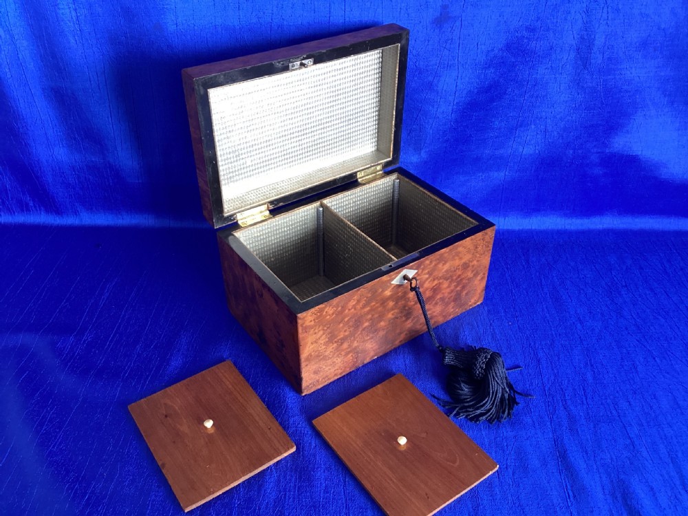 A rectangular Georgian burr walnut tea caddy featuring geometric inlaid borders on the lid and a key with a black tassel. View VIII