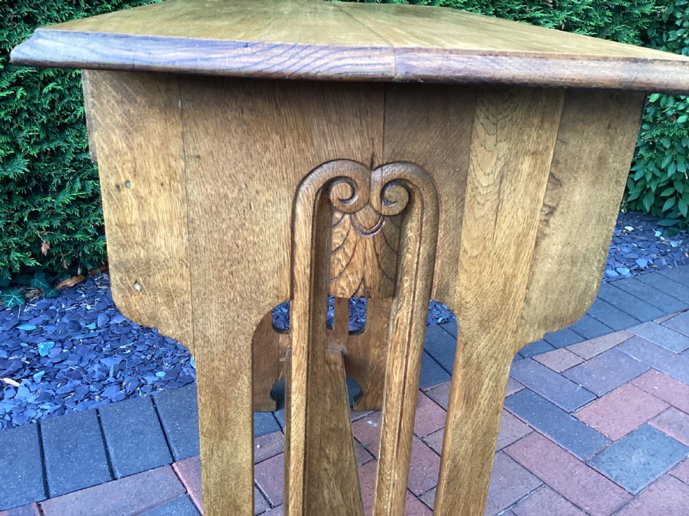 An antique light oak Jugendstil side table featuring two drawers with rectangular brass drop handles, flared side supports, and a lower shelf. View III