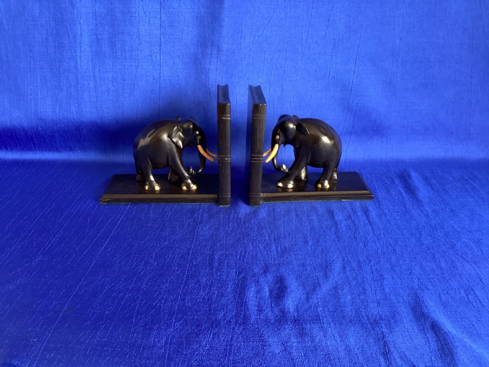 A pair of carved black ebony bookends shaped as elephants with bone tusks and toes. View X