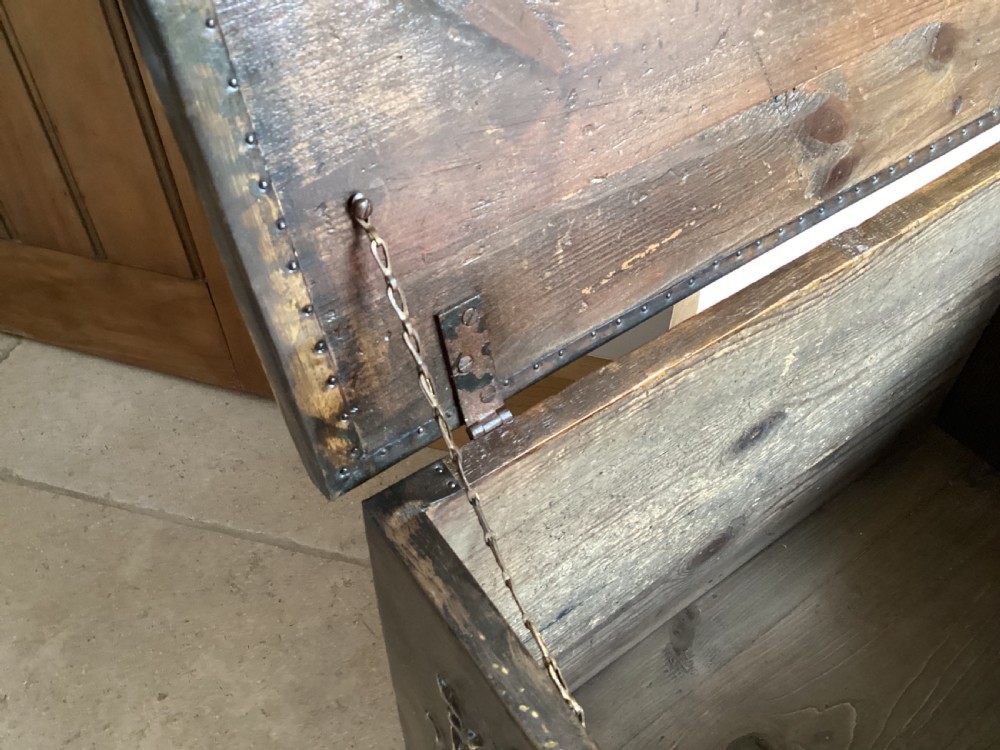 An antique brass-clad wooden fireside log box featuring embossed relief scenes of figures in a tavern on the front and foliate scrollwork on the lid. View XI