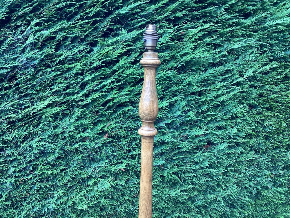 An Edwardian turned oak standard lamp featuring a tapered central column and a stepped circular base. View V