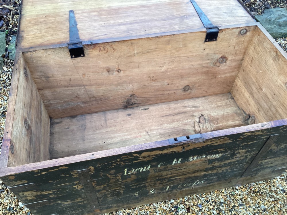 A rectangular antique dark wood military campaign chest featuring stencilled white lettering and iron strap reinforcements. View III