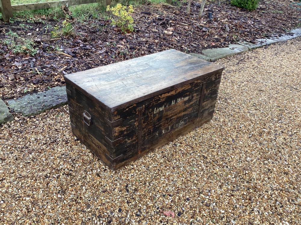 A rectangular antique dark wood military campaign chest featuring stencilled white lettering and iron strap reinforcements. View IV
