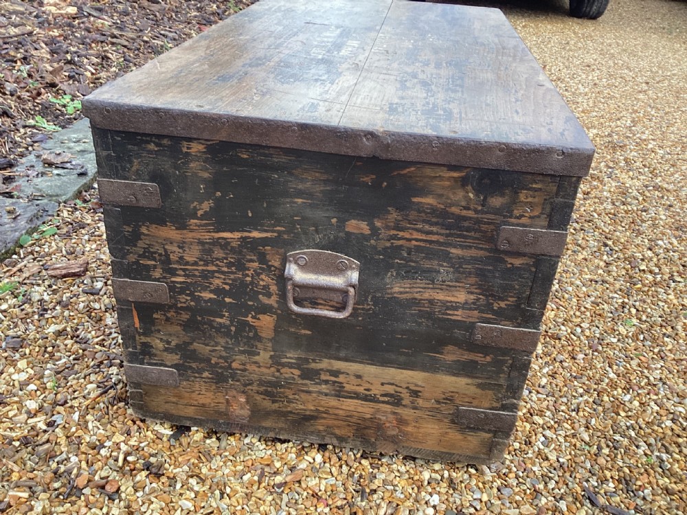 A rectangular antique dark wood military campaign chest featuring stencilled white lettering and iron strap reinforcements. View VIII