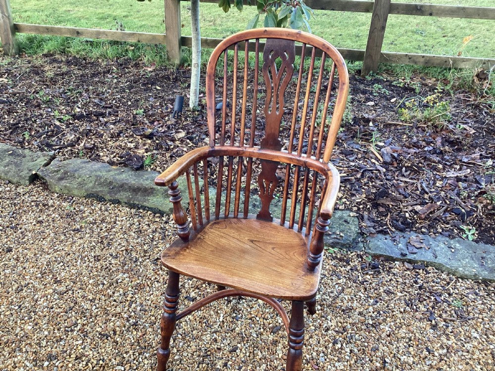 A wooden Georgian Windsor armchair featuring a hoop back, central pierced splat, vertical spindles, shaped seat, turned legs, and curved armrests. View IV