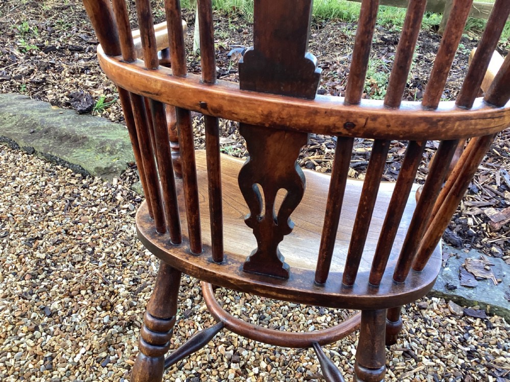 A wooden Georgian Windsor armchair featuring a hoop back, central pierced splat, vertical spindles, shaped seat, turned legs, and curved armrests. View VI