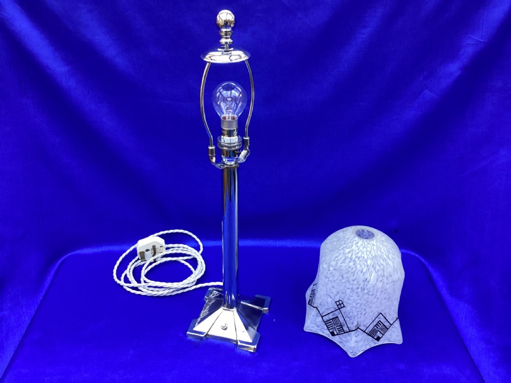 An Art Deco chrome table lamp featuring a central column stem, stepped square base, and a mottled frosted glass bell shade decorated with black geometric diamond motifs. View VII