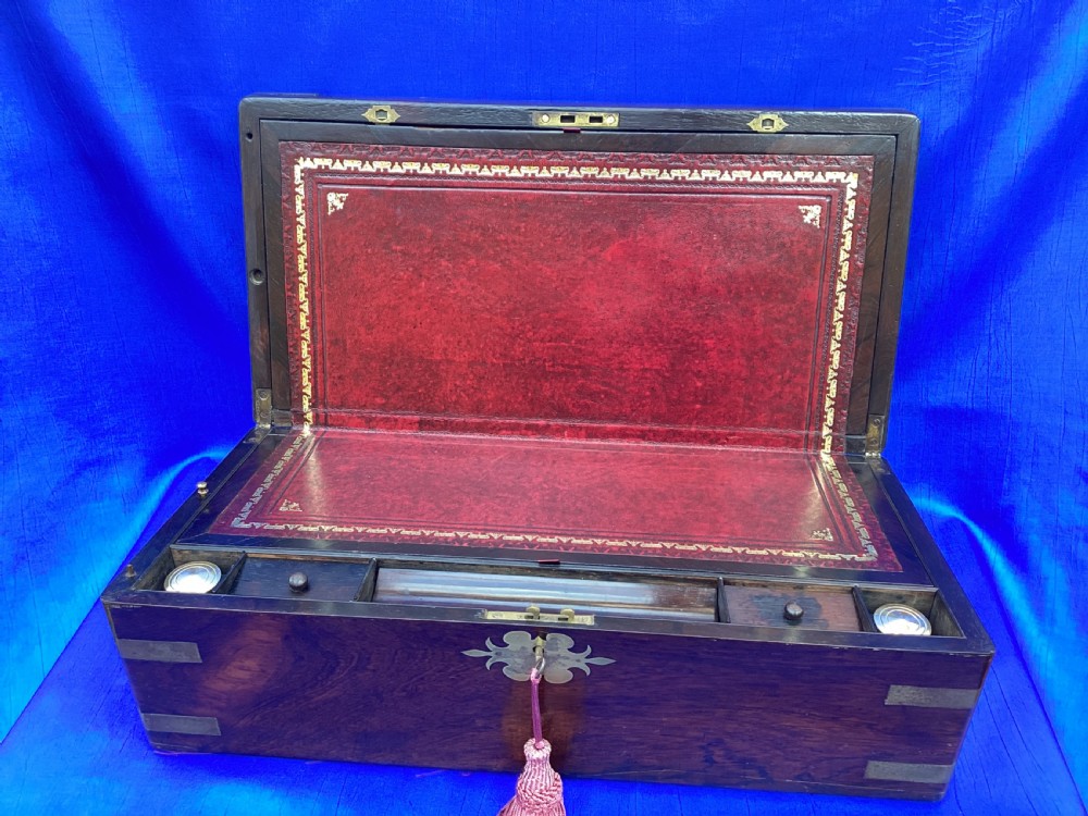 A closed rectangular Georgian rosewood writing slope with polished brass corner mounts and a central brass escutcheon. View V