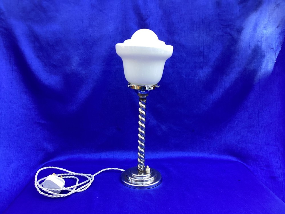 An Art Deco chrome table lamp featuring a twisted spiral stem, a tiered circular base, and a white glass shade. View II