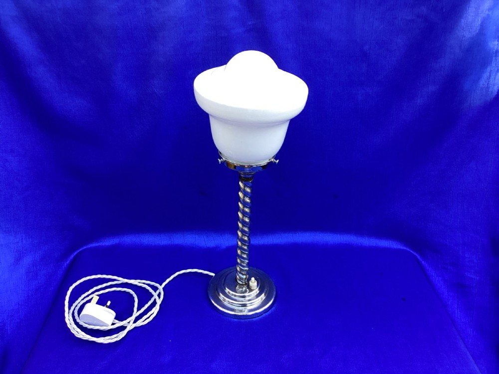 An Art Deco chrome table lamp featuring a twisted spiral stem, a tiered circular base, and a white glass shade. View III