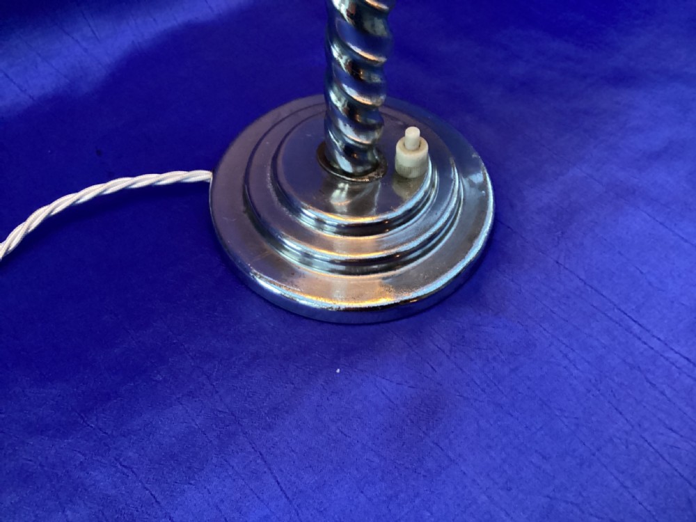 An Art Deco chrome table lamp featuring a twisted spiral stem, a tiered circular base, and a white glass shade. View IV