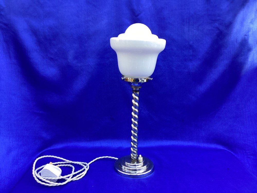 An Art Deco chrome table lamp featuring a twisted spiral stem, a tiered circular base, and a white glass shade. View V