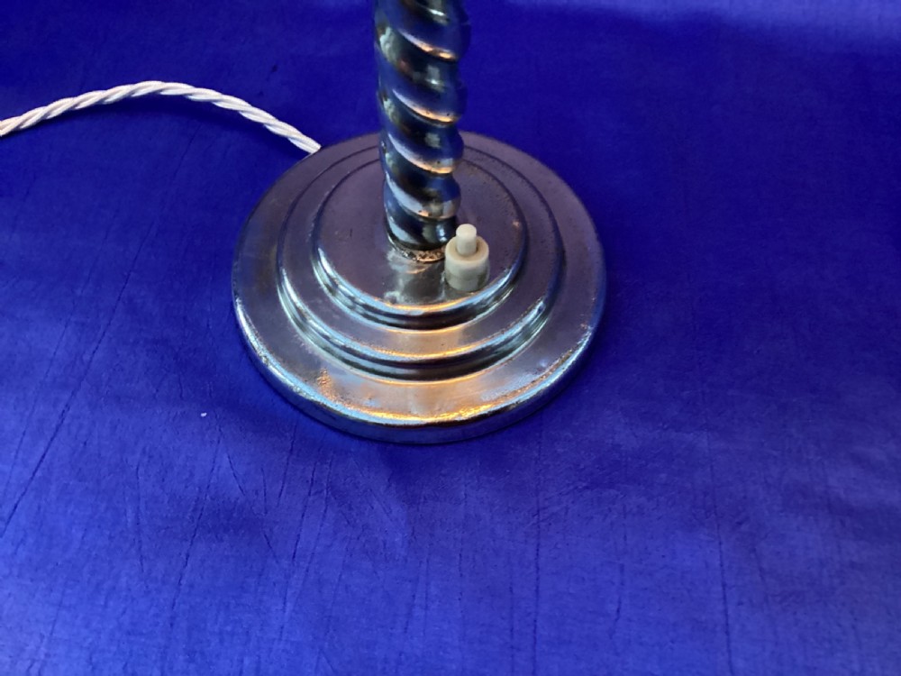An Art Deco chrome table lamp featuring a twisted spiral stem, a tiered circular base, and a white glass shade. View VI