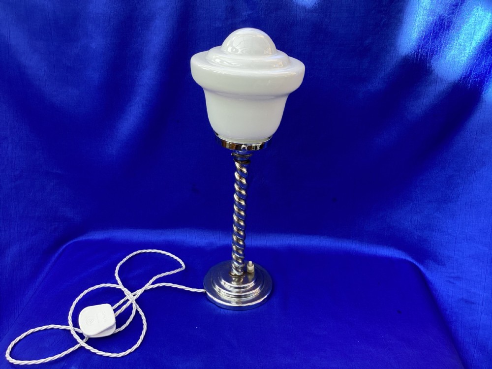 An Art Deco chrome table lamp featuring a twisted spiral stem, a tiered circular base, and a white glass shade. View VIII