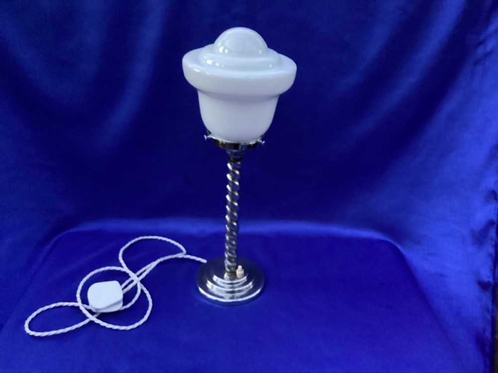 An Art Deco chrome table lamp featuring a twisted spiral stem, a tiered circular base, and a white glass shade. View IX