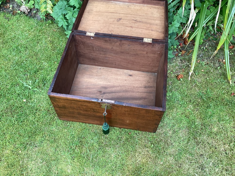 A rectangular Victorian mahogany deed box featuring a hinged lid, polished wood grain, and a central brass escutcheon with an inserted key. View V