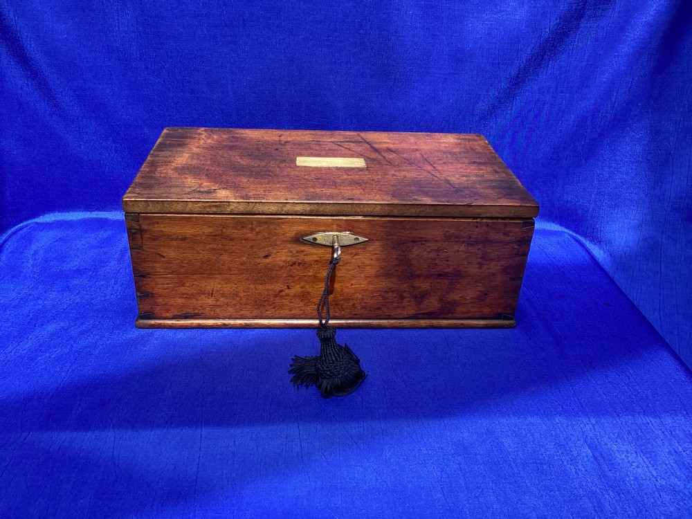 A rectangular Georgian mahogany tool box featuring a hinged lid with a central brass inlay plaque, a keyhole with a brass escutcheon, and visible dovetail joinery.