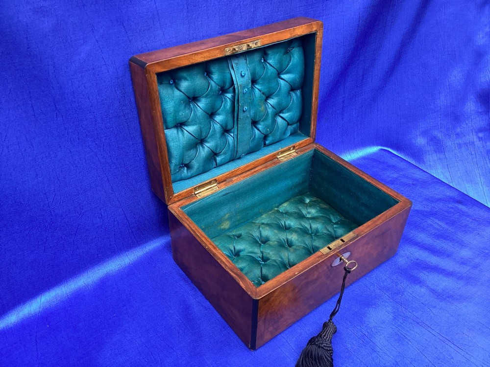 A rectangular Victorian mahogany box with a polished finish, a mother-of-pearl cartouche inlay on the lid, a keyhole escutcheon, and a brass key with a black tassel. View VII