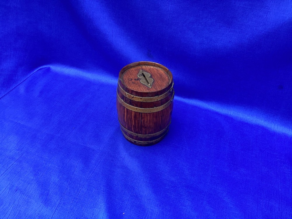 An Edwardian oak money box crafted in the form of a miniature coopered barrel with brass hoops. View III