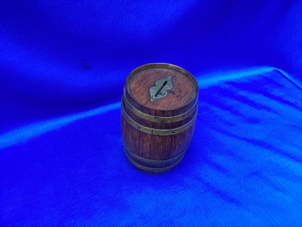 An Edwardian oak money box crafted in the form of a miniature coopered barrel with brass hoops. View IV