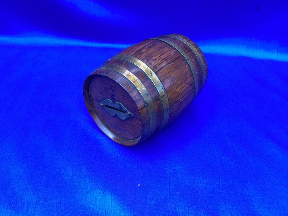An Edwardian oak money box crafted in the form of a miniature coopered barrel with brass hoops. View VII