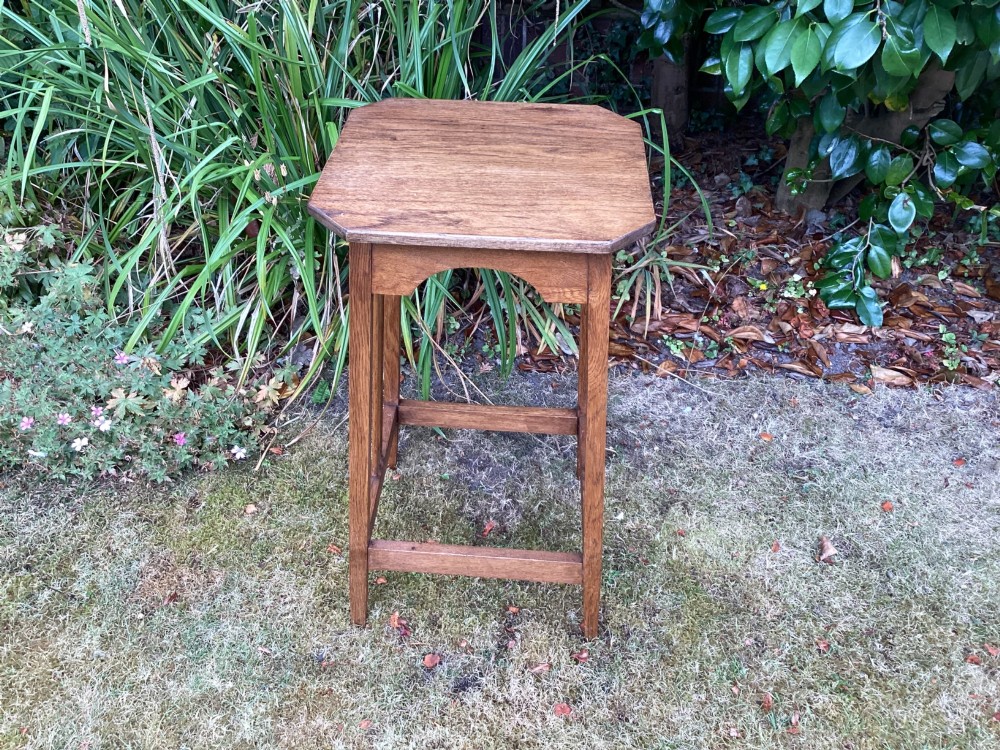 An Arts and Crafts solid oak plant table featuring an octagonal top, pierced cutout side aprons, central vertical slatted supports, and splayed legs with stretchers. View XIII