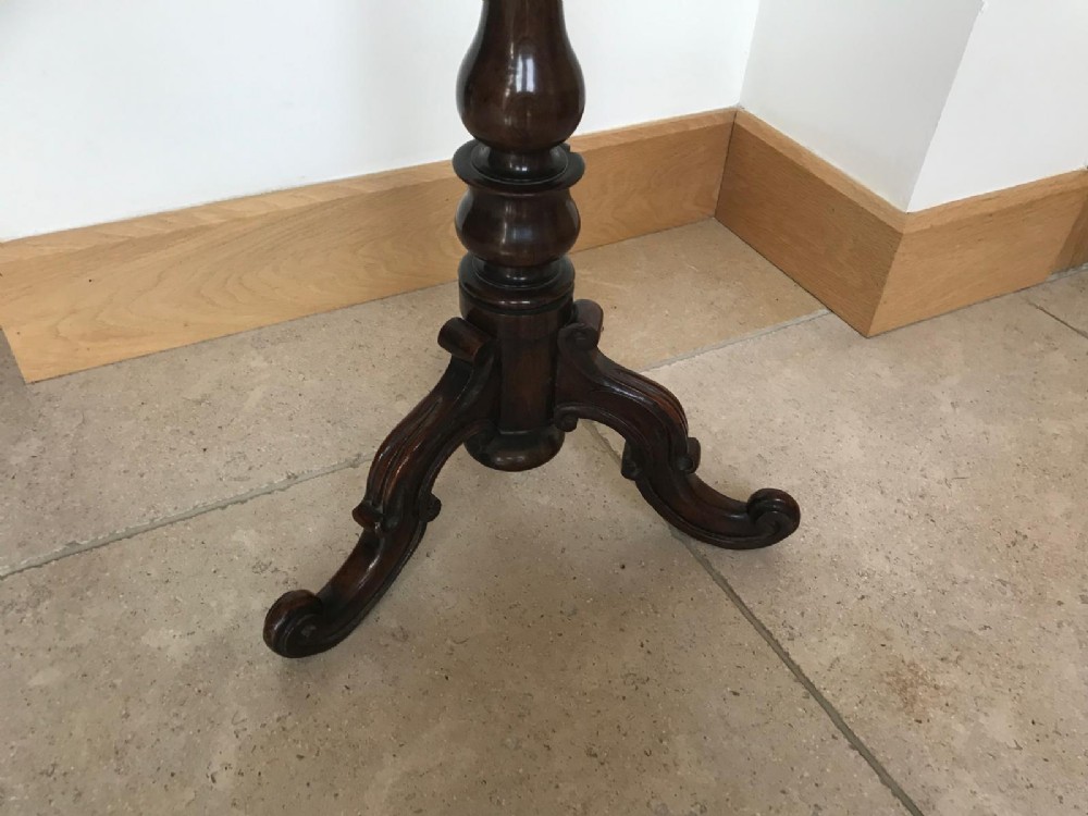 A Victorian rosewood pole screen featuring an oval floral needlework panel mounted on a turned column with a tripod base. View V