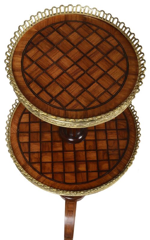 fig 1. A pair of Victorian two-tier etageres featuring parquetry inlaid circular tops, pierced brass galleries, fluted central columns, and tripod bases with gilt mounts.