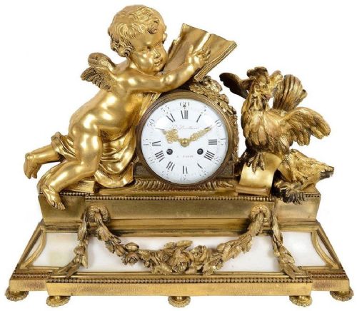 fig 1. A Louis XVI style ormolu and white marble clock garniture set featuring a central putto clock flanked by two matching multi-branch candelabra.
