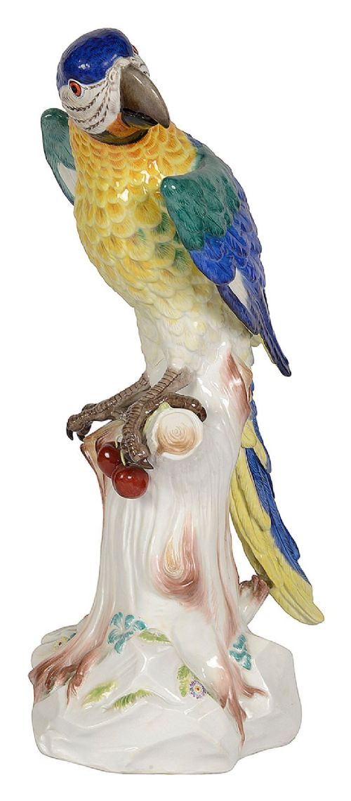 A late 19th-century Meissen porcelain parrot figurine with yellow, blue, and green plumage perched on a tree stump base with red cherries. View II