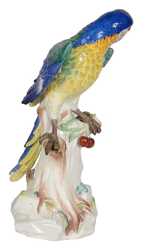 A late 19th-century Meissen porcelain parrot figurine with yellow, blue, and green plumage perched on a tree stump base with red cherries. View VI
