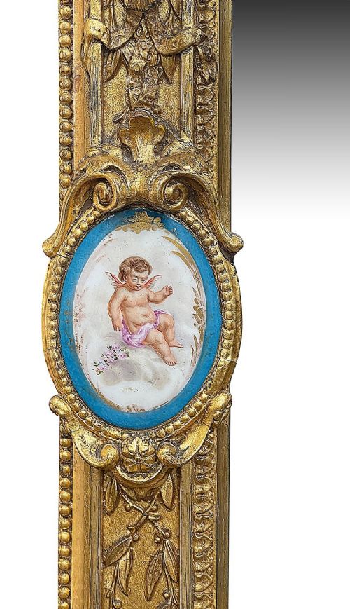 A large gilt-bronze wall mirror featuring an arched crest with sculpted putti, foliage mouldings, and oval Sevres porcelain plaques set along the frame. View V