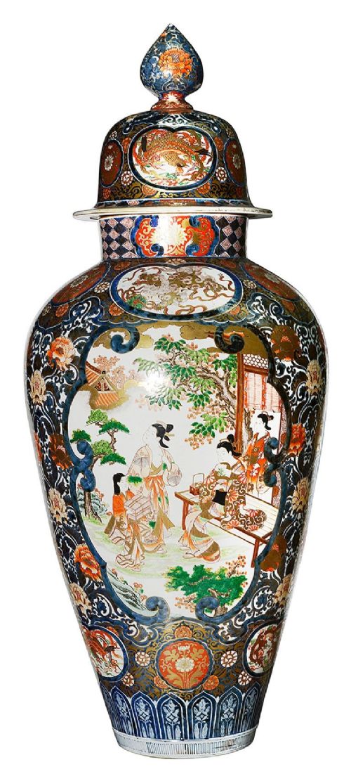 A pair of large 19th-century Japanese Imari porcelain lidded vases featuring painted reserves depicting figures in garden settings, surrounded by cobalt blue, orange, green, and gold patterns. View IX