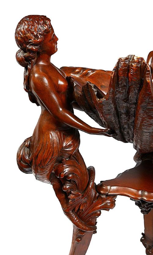 fig 2. An 18th-century style carved walnut jardiniere featuring three mythical figures supporting a large shell basin on a tripod base.