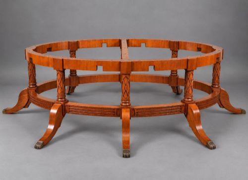 fig 3. A large oval burr walnut extending dining table featuring decorative satinwood crossbanding and pedestal legs fitted with brass castors.