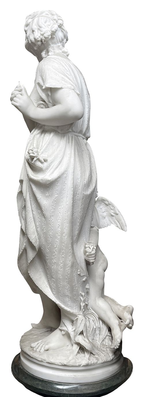 A 19th-century white Carrara marble statue depicting a classical female figure in draped robes with a winged putto at her side. View II