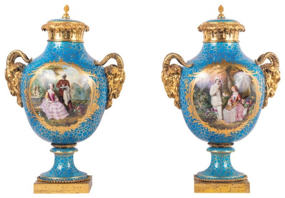 A pair of nineteenth-century turquoise blue Sevres style porcelain urns with gilded bronze ram head handles and hand-painted figurative panels.
