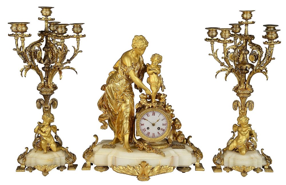 A nineteenth-century French gilt bronze and marble clock garniture set comprising a central mantel clock decorated with classical figures and two matching multi-arm candelabra.