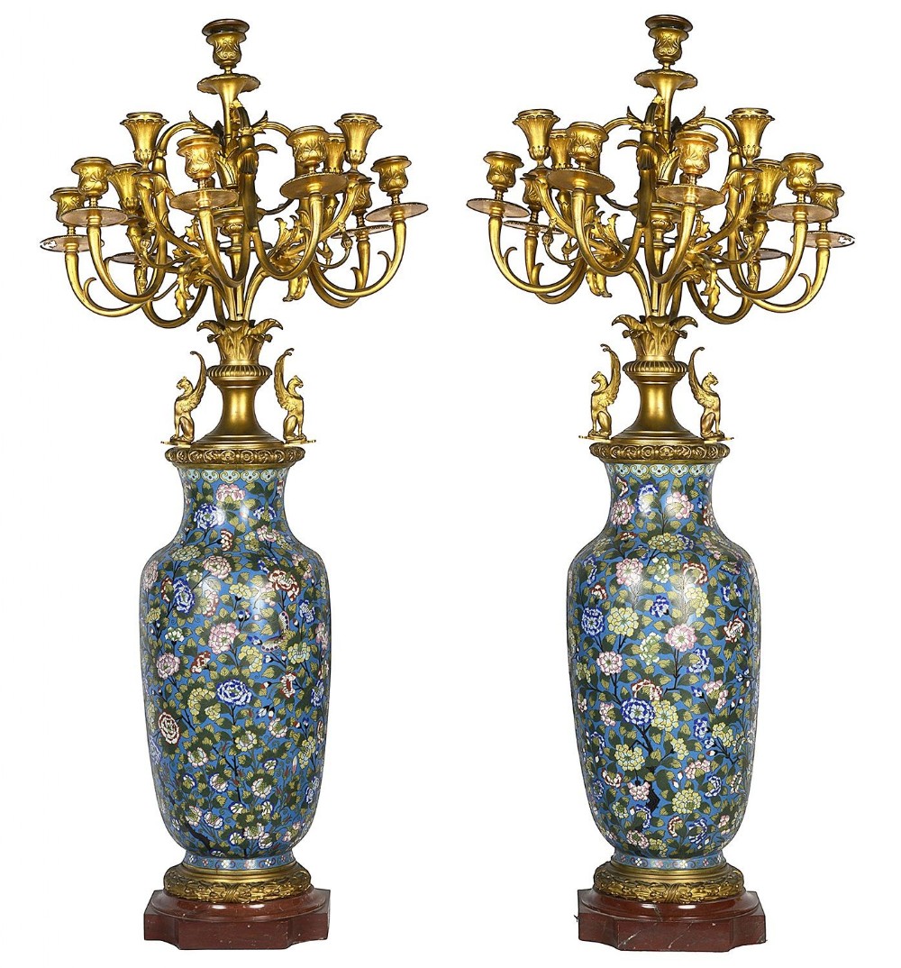 A pair of 19th-century French candelabra featuring blue floral cloisonne enamel vase bodies, multi-arm gilt-bronze candle sockets, and square marble bases.