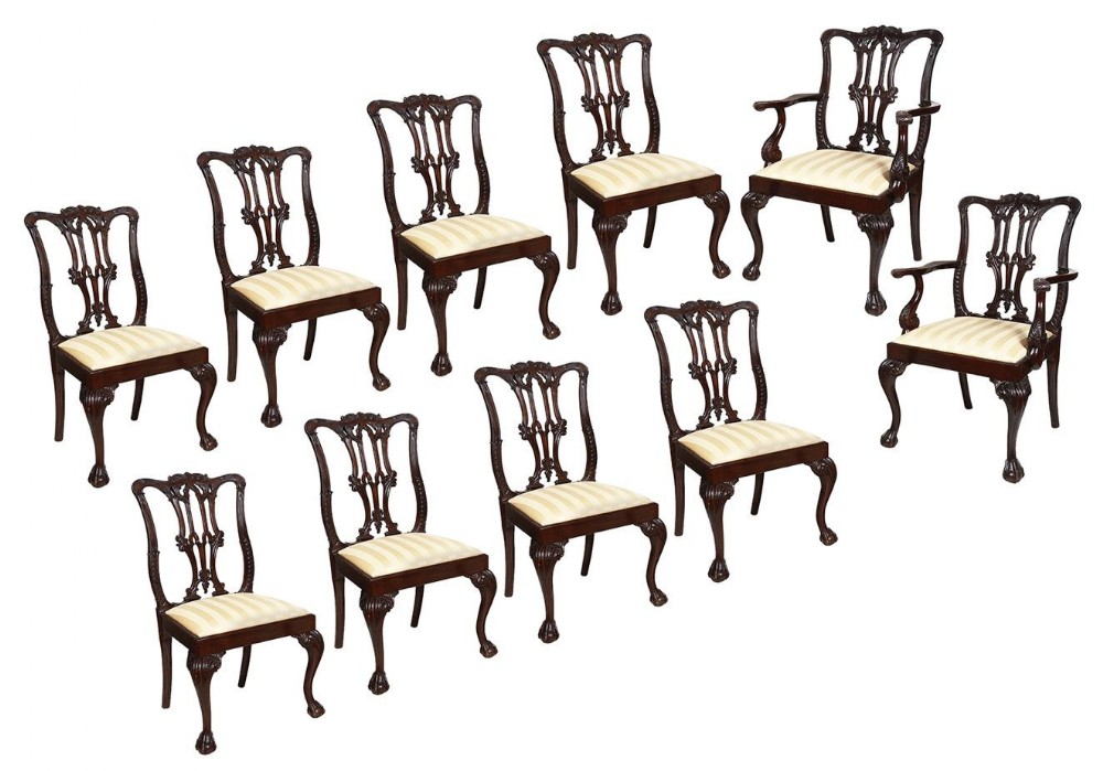 A set of ten 19th-century Chippendale style mahogany dining chairs featuring carved pierced splats, ball-and-claw feet, and striped seats.