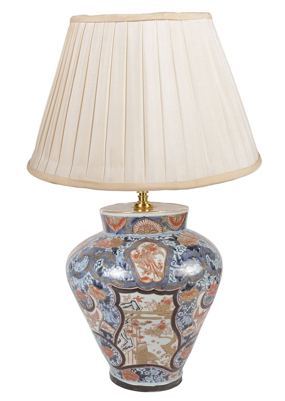 An antique Japanese Imari porcelain vase converted into a table lamp, featuring blue, red, and gold hand-painted panels beneath a pleated cream fabric shade.