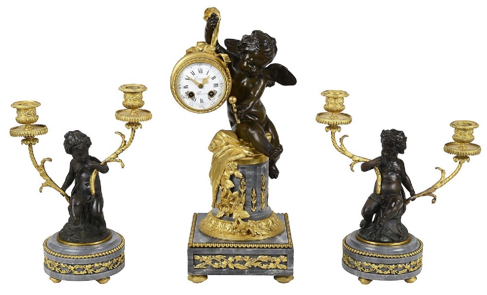 A 19th-century French three-piece garniture set featuring a central patinated bronze cherub holding a clock atop a grey marble base, flanked by a pair of matching bronze cherub two-light candelabra.