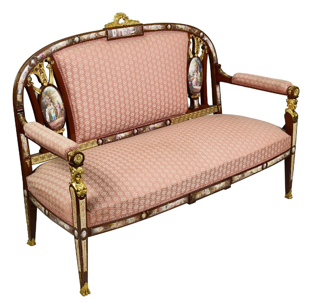A 19th-century Viennese mahogany sofa featuring patterned rose pink upholstery, gilt bronze caryatid mounts, and hand-painted enamel plaques.